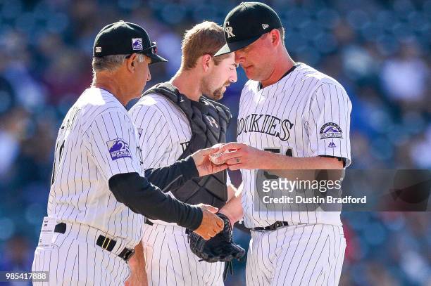 Jake McGee of the Colorado Rockies is relieved by Bud Black of the Colorado Rockies during a game against the Miami Marlins at Coors Field on June...