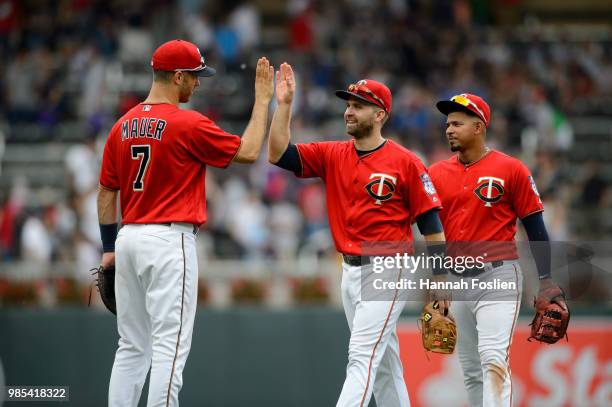 Joe Mauer, Brian Dozier and Eduardo Escobar of the Minnesota Twins celebrate defeating the Texas Rangers after the game on June 24, 2018 at Target...