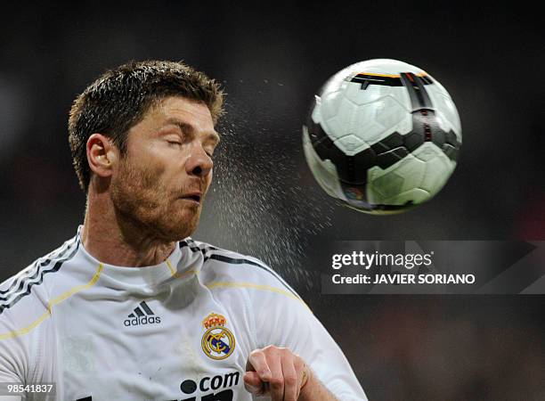 Real Madrid's midfielder Xabi Alonso heads a ball during the Spanish League football match Real Madrid against Valencia at the Santiago Bernabeu...