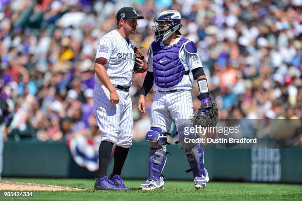 Bryan Shaw and Tony Wolters of the Colorado Rockies meet on the mound during a game against the Miami Marlins at Coors Field on June 23, 2018 in...