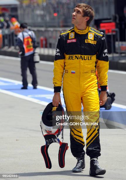 Renault driver Vitaly Petrov of Russia walks back to the garage after crashing on the final corner during the third qualifying session for the...