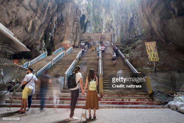 young couple exploring batu caves near kuala lumpur, malaysia - batu caves stock pictures, royalty-free photos & images