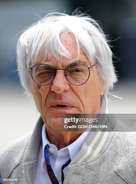 Formula One supremo Bernie Ecclestone chats with a friend prior to the start of the final qualifying session of Formula One's Chinese Grand Prix in...
