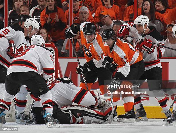 Martin Brodeur of the New Jersey Devils makes a save against Mike Richards and Simon Gagne of the Philadelphia Flyers in Game Three of the Eastern...
