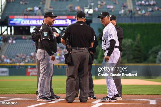 Fredi Gonzalez of the Miami Marlins and Bud Black of the Colorado Rockies meet with the umpires to go over ground rules before a game at Coors Field...