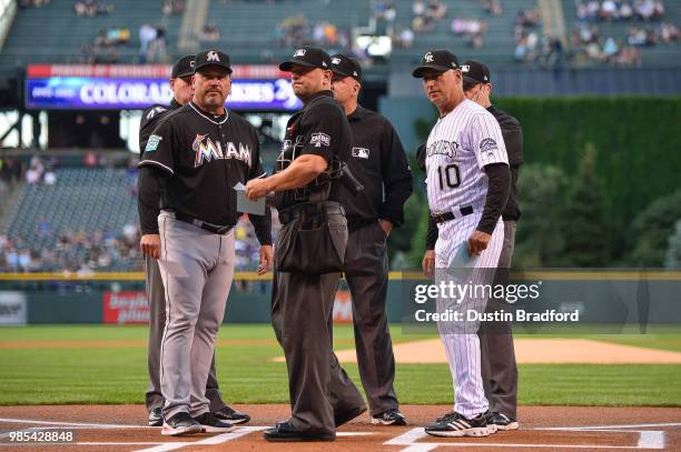 Fredi Gonzalez of the Miami Marlins and Bud Black of the Colorado Rockies meet with the umpires to go over ground rules before a game at Coors Field...