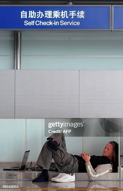 Passenger waits on the floor of Beijing Capital International airport after flights from China to Europe were cancelled on April 19, 2010. More than...