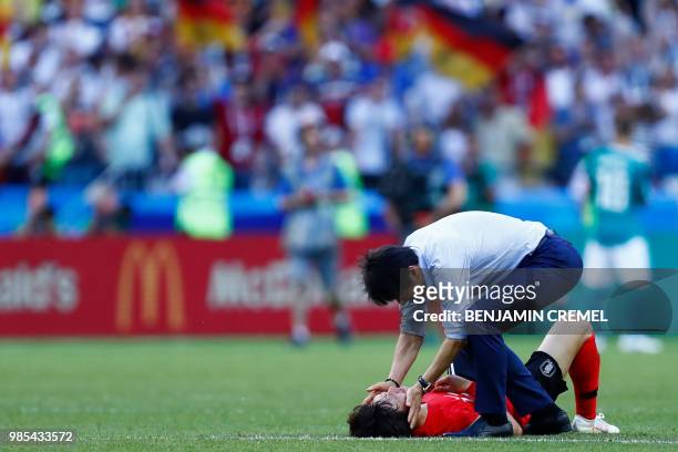 South Korea's coach Shin Tae-yong consoles South Korea's midfielder Lee Jae-sung following their disqualification during the Russia 2018 World Cup...
