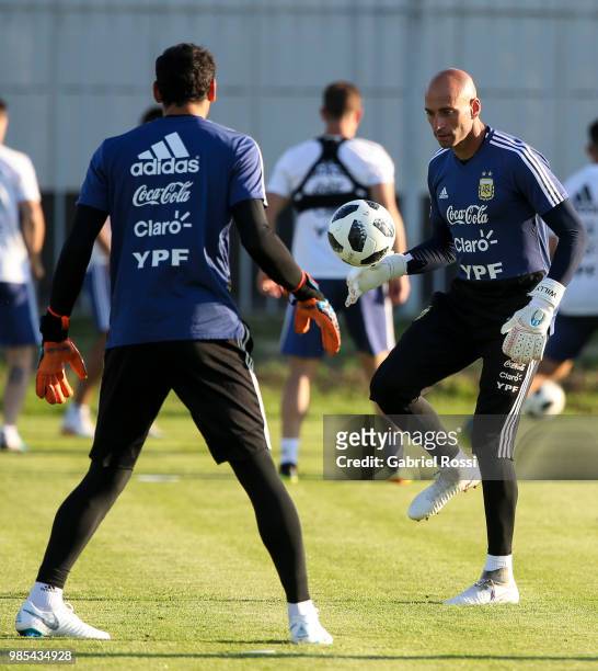 Wilfredo Caballero of Argentina and Nahuel Guzman of Argentina warm up during a training session at Stadium of Syroyezhkin sports school on June 27,...