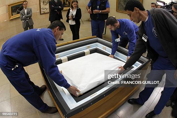 Staff members of the Orsay museum pack "L'Angelus" a painting by French Jean-Francois Millet on April 19, 2010 in Paris. The painting will be shown...