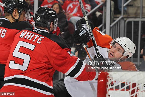 Mike Richards of the Philadelphia Flyers is checked by Colin White of the New Jersey Devils in Game Two of the Eastern Conference Quarterfinals...