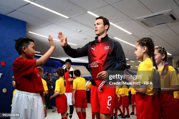 Stephan Lichtsteiner of Switzerland greets a mascot in the tunnel prior to the 2018 FIFA World Cup Russia group E match between Switzerland and Costa...