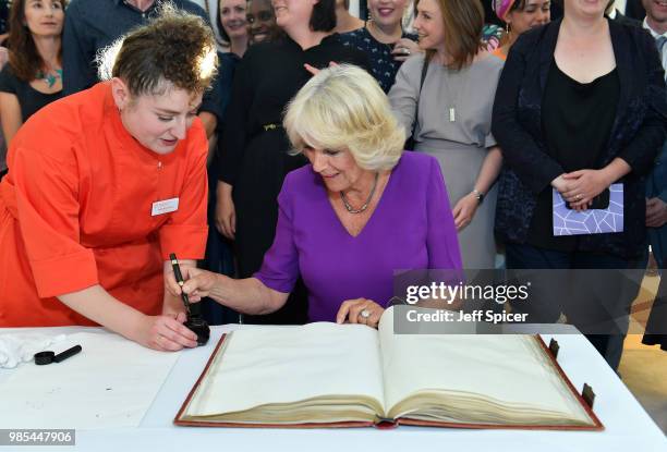 Camilla, Duchess of Cornwall signs the Roll book with T S Elliots pen at The Royal Society of Literature '40 Under 40' fellow induction at The...