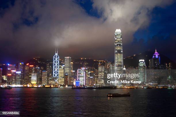 Clouds form over the peak at sunset and collect over Hong Kongs dramatic night skyline in Hong Kong, China. Many of Hong Kongs distinctive buildings...