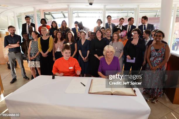 Camilla, Duchess of Cornwall signs the Roll book with T S Elliots pen infront of the new fellows and Molly Rosenberg, Director of Royal Society of...