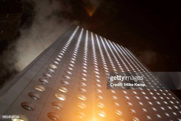 Jardine House lit up at night on Connaught Place, Central Hong Kong, China. At 52 floors and 179m Jardine House was Hong Kong, and in fact Asias...