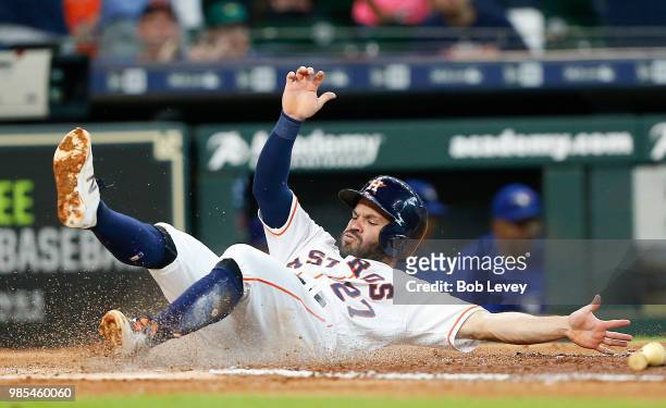 Jose Altuve of the Houston Astros scores on a double by Evan Gattis in the first inning against the Toronto Blue Jays at Minute Maid Park on June 27,...