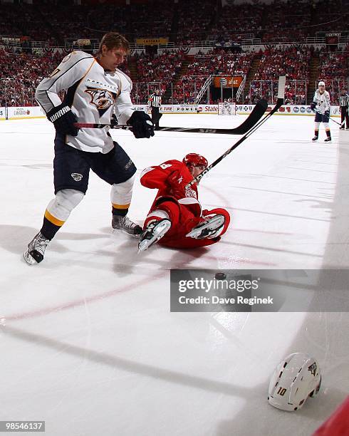 Martin Erat of the Nashville Predators hauls down Darren Helm#43 of the Detroit Red Wings and gets a penalty during an NHL game at Joe Louis Arena on...