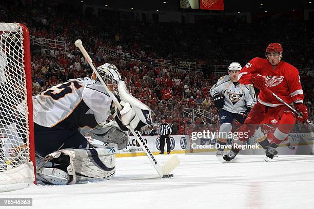 Goaltender Pekka Rinne of the Nashville Predators controls the puck as Valtteri Filppula of the Detroit Red Wings skates in during an NHL game at Joe...