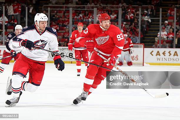 Johan Franzen of the Detroit Red Wings tries to skate by the defense of Marc Methot of the Columbus Blue Jackets during an NHL game at Joe Louis...