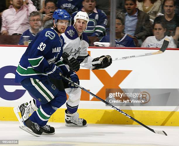 Henrik Sedin of the Vancouver Canucks and Ryan Smyth of the Los Angeles Kings skate up ice in Game One of the Western Conference Quarterfinals during...