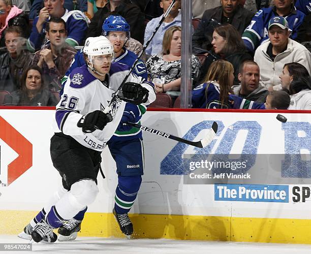 Henrik Sedin of the Vancouver Canucks and Michal Handzus of the Los Angeles Kings watch a loose puck in Game Two of the Western Conference...