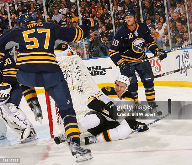 Miroslav Satan of the Boston Bruins is knocked to the ice between Tyler Myers and Henrik Tallinder of the Buffalo Sabres in Game Two of the Eastern...