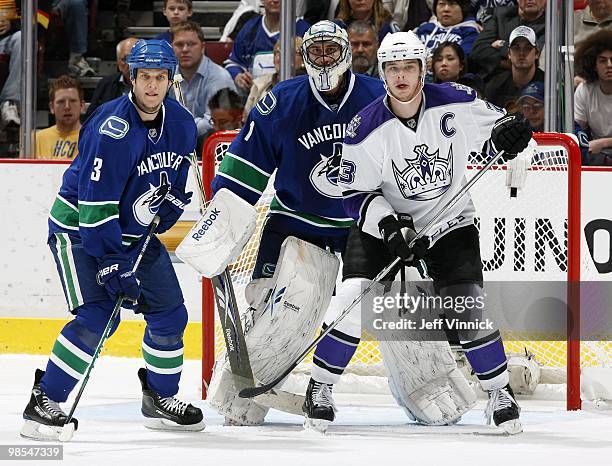 Dustin Brown of the Los Angeles Kings and Kevin Bieksa of the Vancouver Canucks stand in front of Roberto Luongo of the Vancouver Canucks in Game Two...