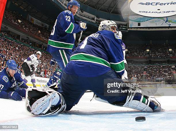 Ryan Kesler and Alexander Edler of the Vancouver Canucks look on as Anze Kopitar of the Los Angeles Kings scores the overtime winning goal on Roberto...