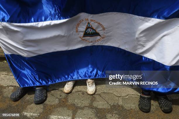 People display a Nicaraguan national flag as leaders of anti-government demonstrators, including neighbourhood, student and peasant groups, give a...