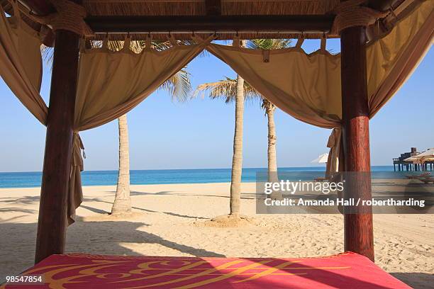 four poster sunlounger on jumeirah beach and the burj al arab hotel, jumeirah beach, dubai, united arab emirates, middle east - hotel jumeirah beach fotografías e imágenes de stock