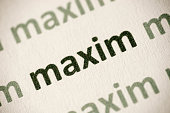 word maxim printed on paper macro