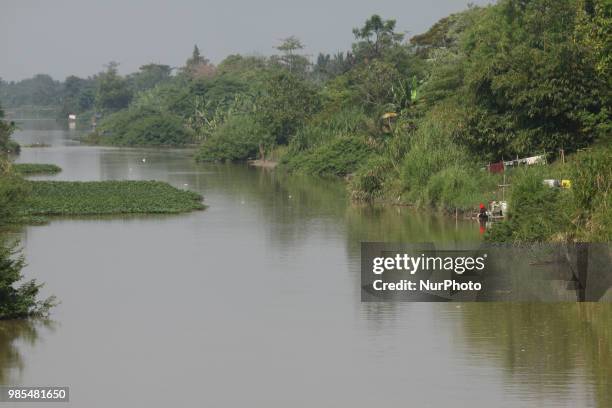 Women wash clothes on the CBL riverside, Bekasi regency, West Java, June 27, 2018. Although the river water has been contaminated with industrial...