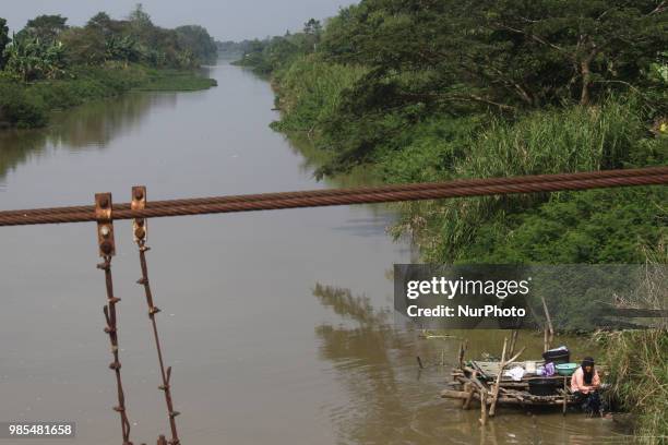 Women wash clothes on the CBL riverside, Bekasi regency, West Java, June 27, 2018. Although the river water has been contaminated with industrial...