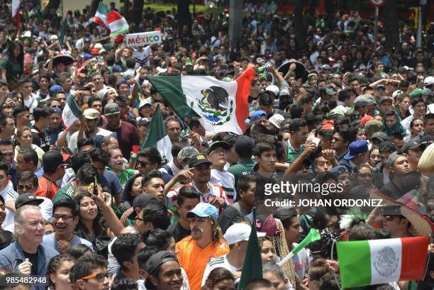 Football fans watch the World Cup match between Mexico and Sweden on a screen at the Angel de la Independencia Monument in Mexico City, on June 27,...