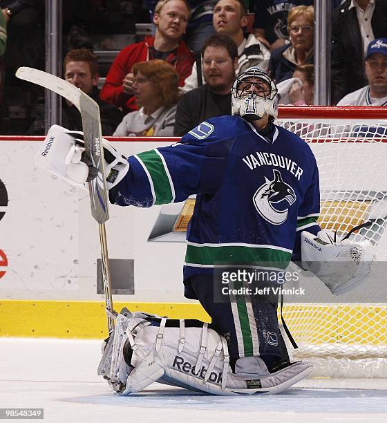 Roberto Luongo of the Vancouver Canucks tries to remove his goal stick after getting it caught in his pad strap in Game One of the Western Conference...