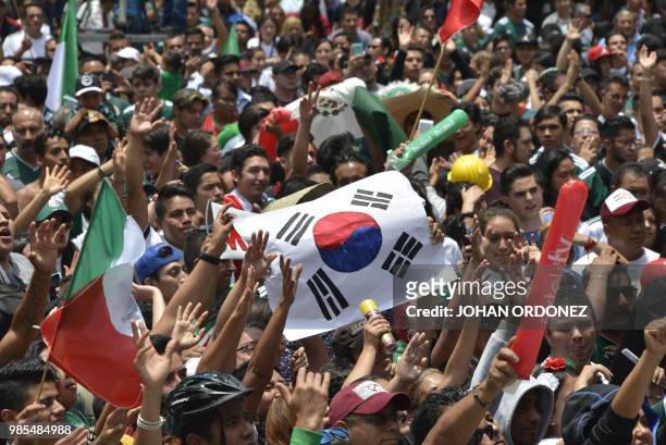 Football fan holds a flag of South Korea as thousands watch the World Cup match between Mexico and Sweden on a screen at the Angel de la...