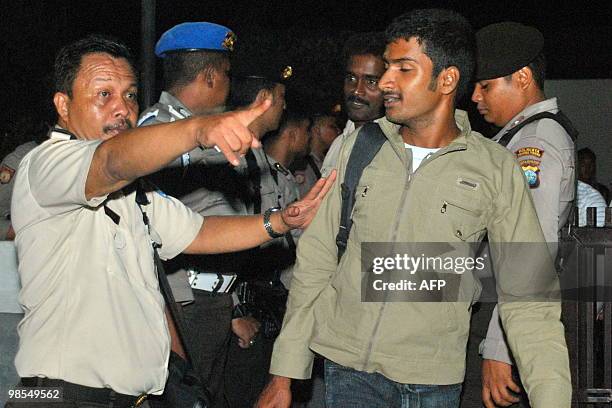 Indonesian police and immigration officials direct Sri Lankan ethnic Tamil migrants soon after they are landed at Tanjung Pinang airport in Riau...