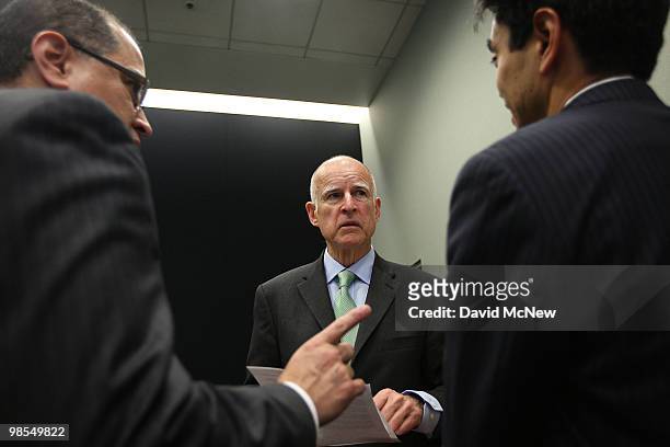California Attorney General and gubernatorial candidate Jerry Brown speaks with his attorneys as he prepares to address a press conference to...