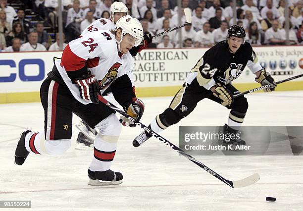 Anton Volchenkov of the Ottawa Senators handles the puck in front of Matt Cooke of the Pittsburgh Penguins in Game Two of the Eastern Conference...
