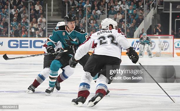 Scott Hannan of the Colorado Avalanche keeps his eyes on the puck in front of Joe Pavelski of the San Jose Sharks in Game One of the Western...
