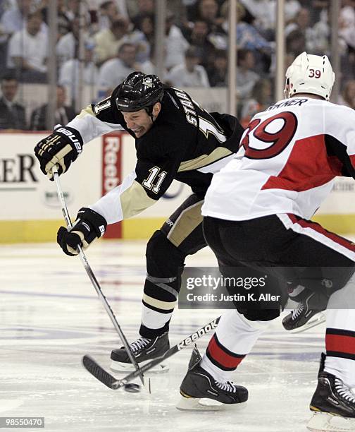 Jordan Staal of the Pittsburgh Penguins takes a shot on goal in front of Matt Carkner of the Ottawa Senators in Game Two of the Eastern Conference...