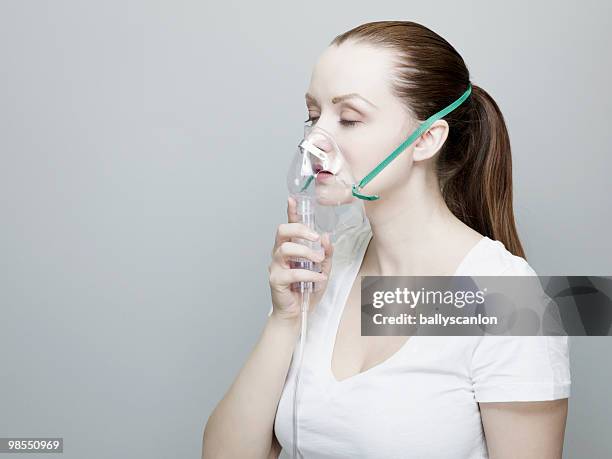 woman wearing an oxygen mask. - oxygen mask stock pictures, royalty-free photos & images