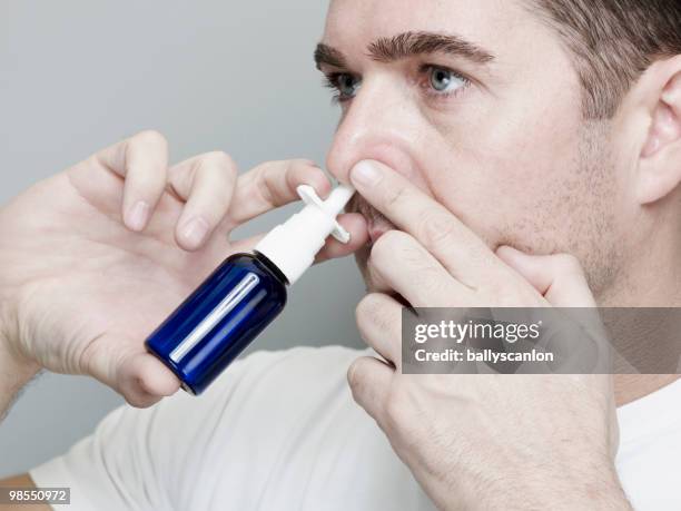 man using nasal spray inhaler. - nasal spray stock pictures, royalty-free photos & images