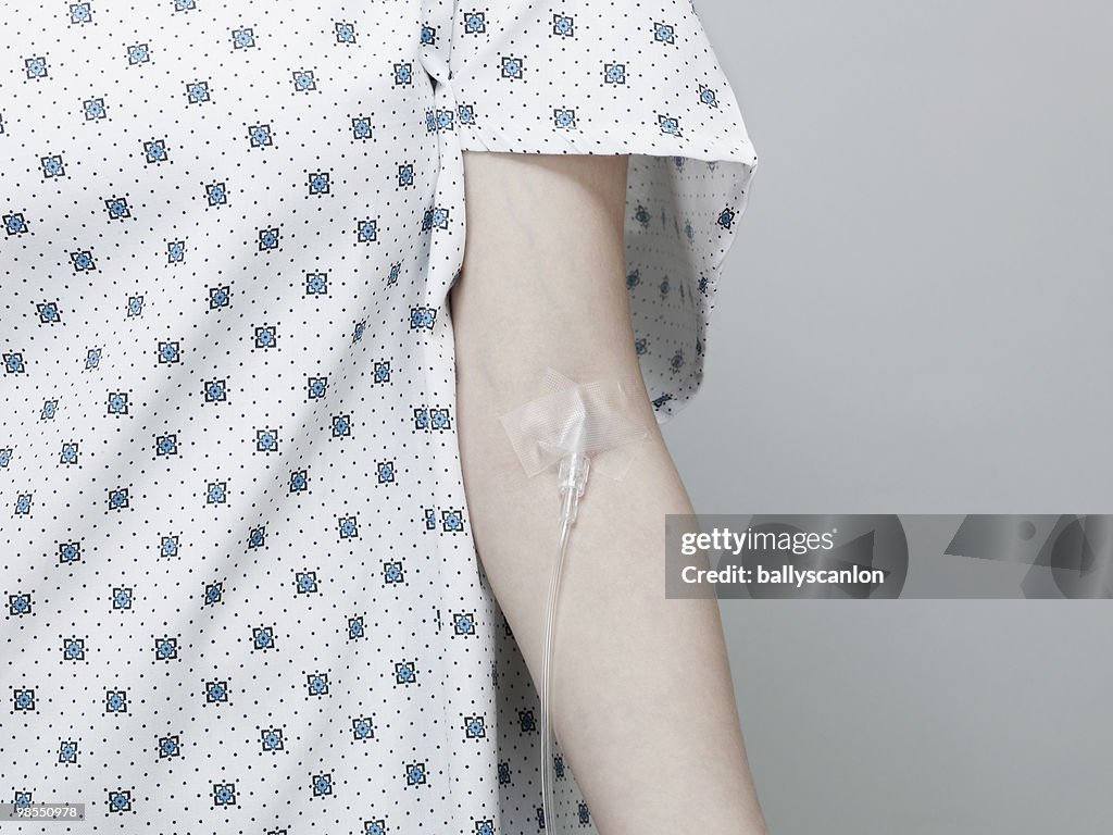 Woman Wearing Hospital Gown with Intravenous Drip.