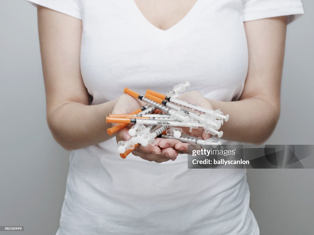 Woman Holding Many Insulin Syringes.