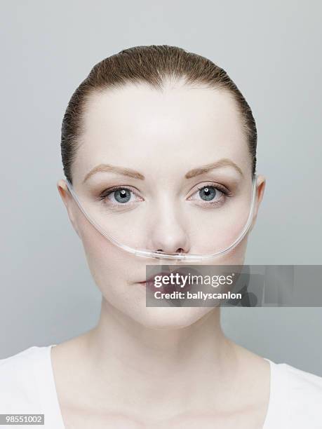 woman wearing a nasal oxygen tube. - oxygen tube stock pictures, royalty-free photos & images