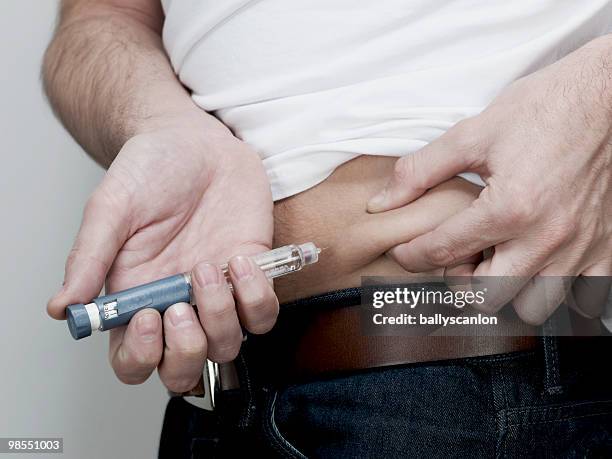 man injecting himself with insulin pen in stomach. - injecting stomach stock pictures, royalty-free photos & images