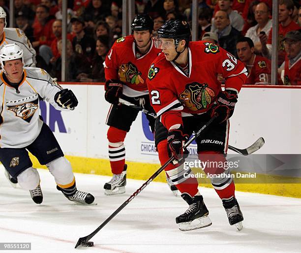 Kris Versteeg of the Chicago Blackhawks looks to pass the puck in front of teammate John Madden and Ryan Suter the Nashville Predators in Game One of...