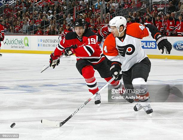 Kimmo Timonen of the Philadelphia Flyers and Travis Zajac of the New Jersey Devils skate hard for a loose puck in Game Two of the Eastern Conference...